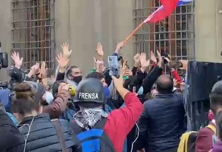 Constituyentes con las manos en Alto intentan impedir el avance del guanaco, en afueras del Congreso en Santiago